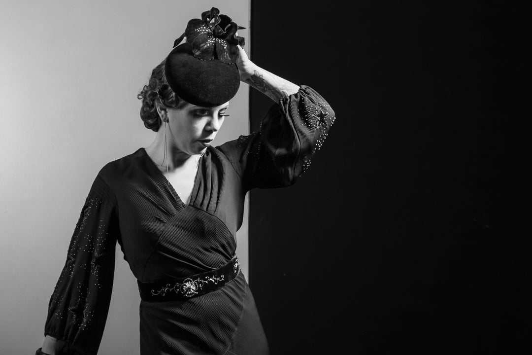 Black and white image of women in dress wearing floral hat