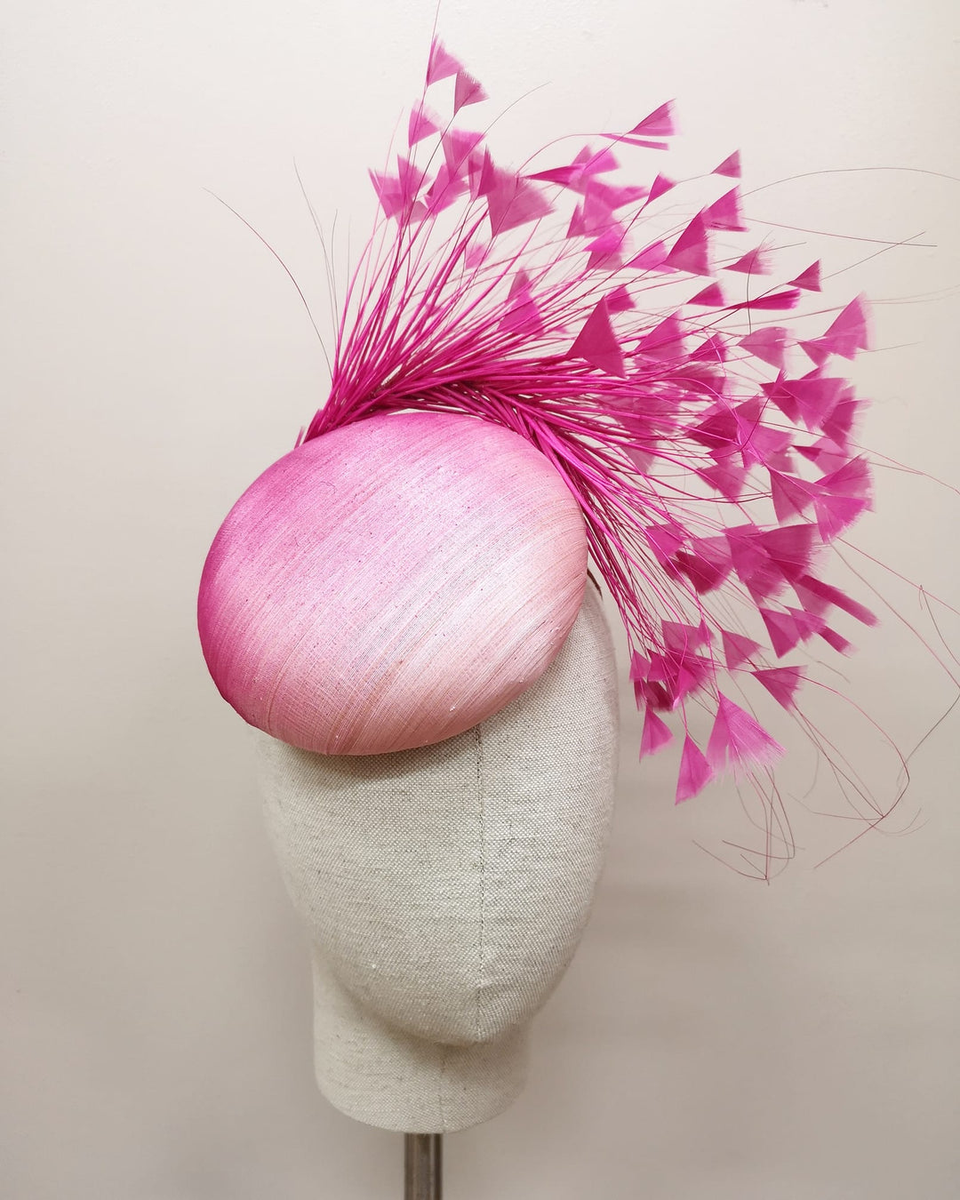 Pink cocktail hat with feathers on a mannequin