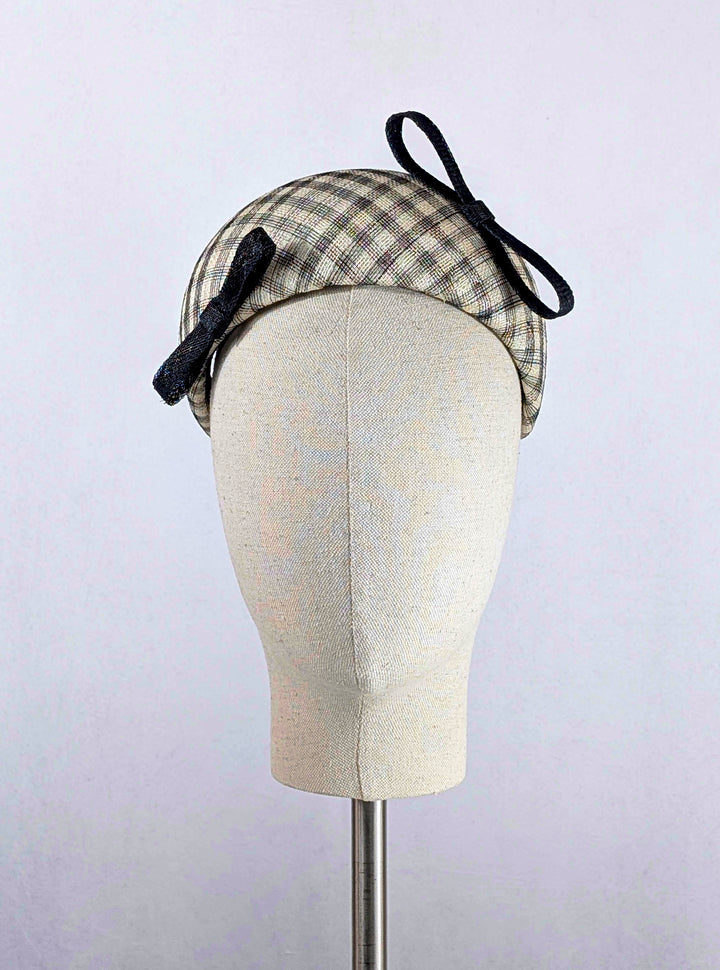 Plaid headband with bows on a mannequin head against a gray background