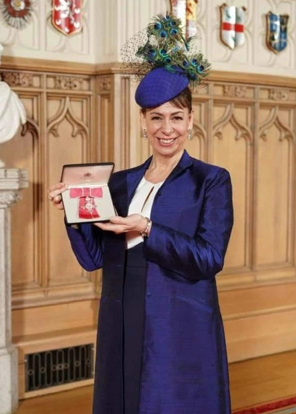 Woman in formal attire holding an award in a wood paneled room
